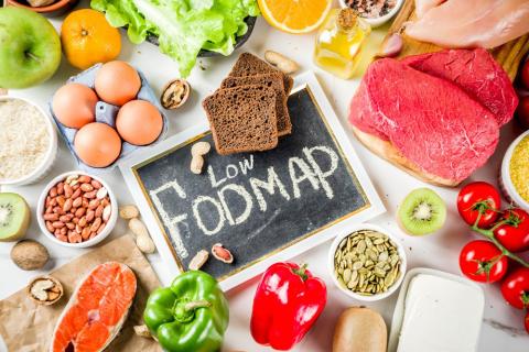 Photo of various foods with a chalkboard in the center reading Low FODMAP